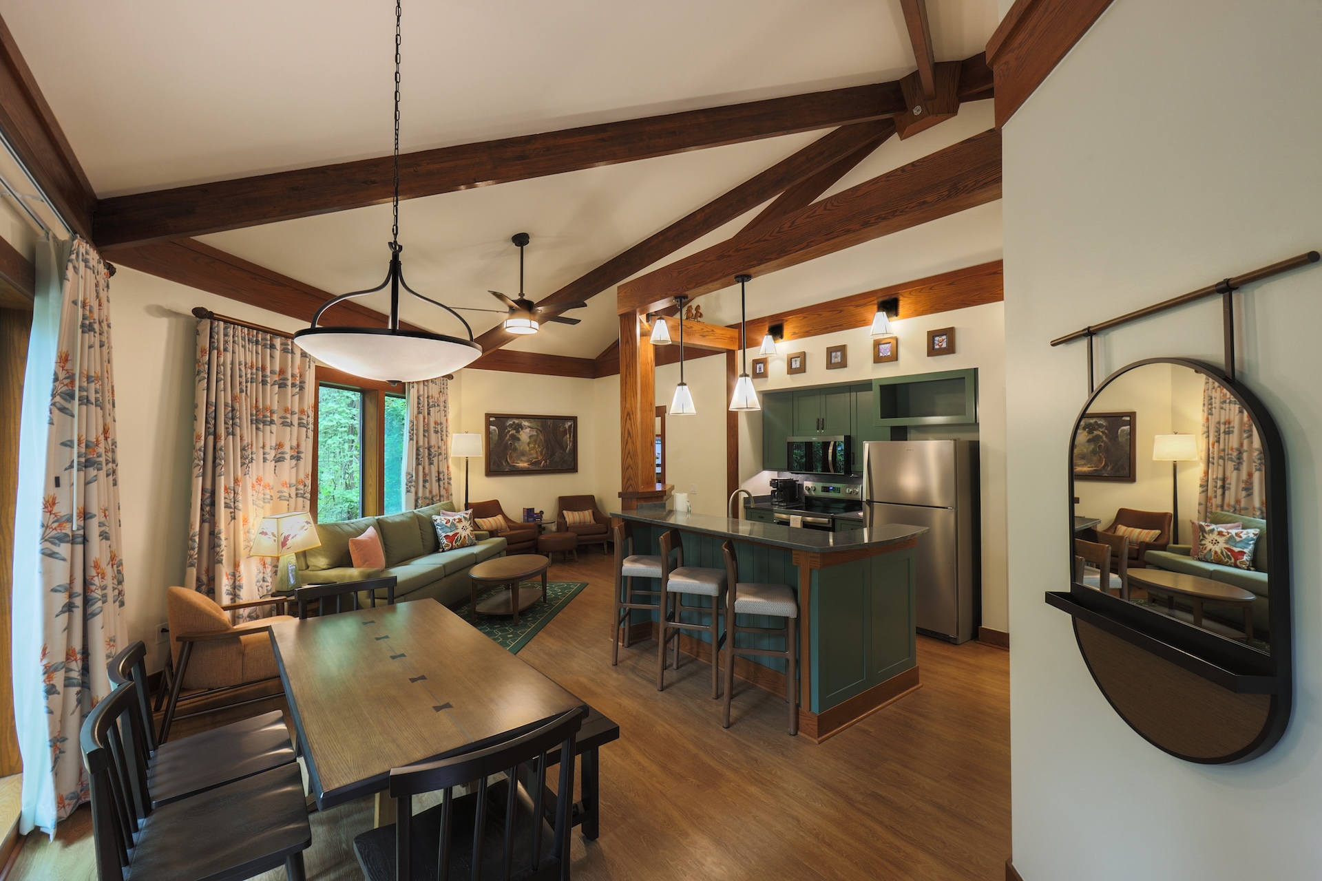 Saratoga Springs new DVC villas. The image showcases a modern, elegantly designed living space featuring a kitchen and dining area. The aesthetic includes wooden beams, stylish furnishings, and a mix of cozy and contemporary elements.