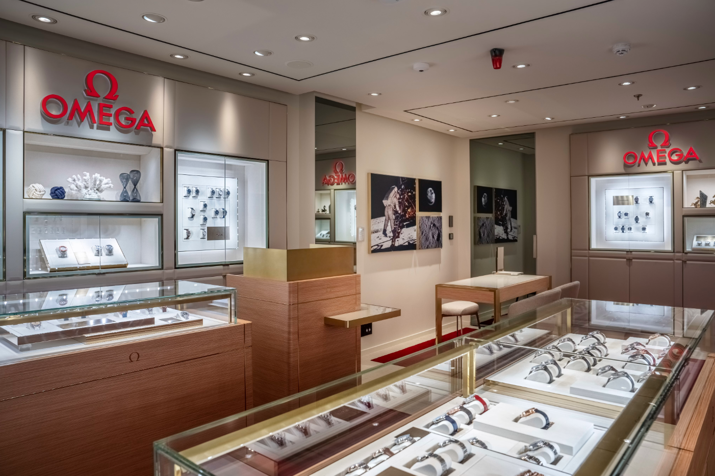 The image depicts the interior of an upscale watch store featuring displays of luxury watches. Prominent branding is visible on the walls and displays, highlighting the Omega brand.