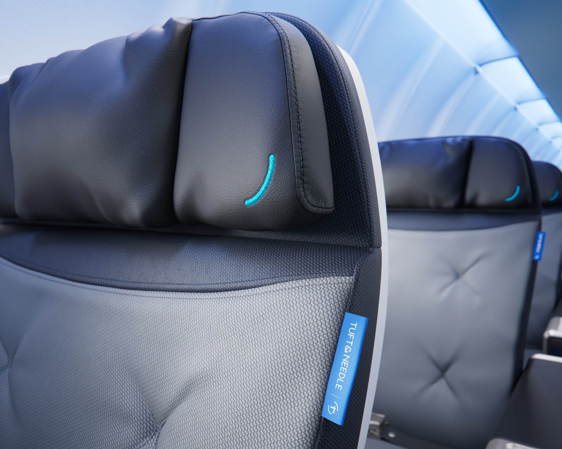 The image features a close-up view of a modern airplane seat headrest, highlighting a sleek design with a dark blue and grey color scheme. The headrest is fitted with a small accent detail, reflecting contemporary airline interior aesthetics.