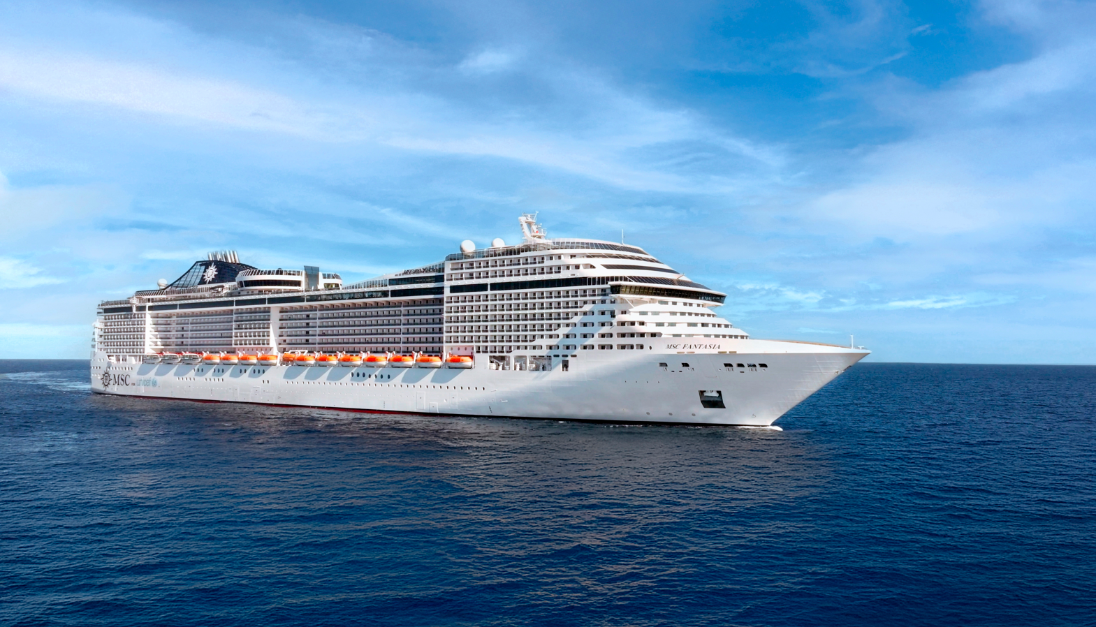 The image features a large cruise ship, likely from a major cruise line, traversing calm ocean waters under a blue sky. The ship showcases multiple decks and is designed for passenger comfort and leisure.